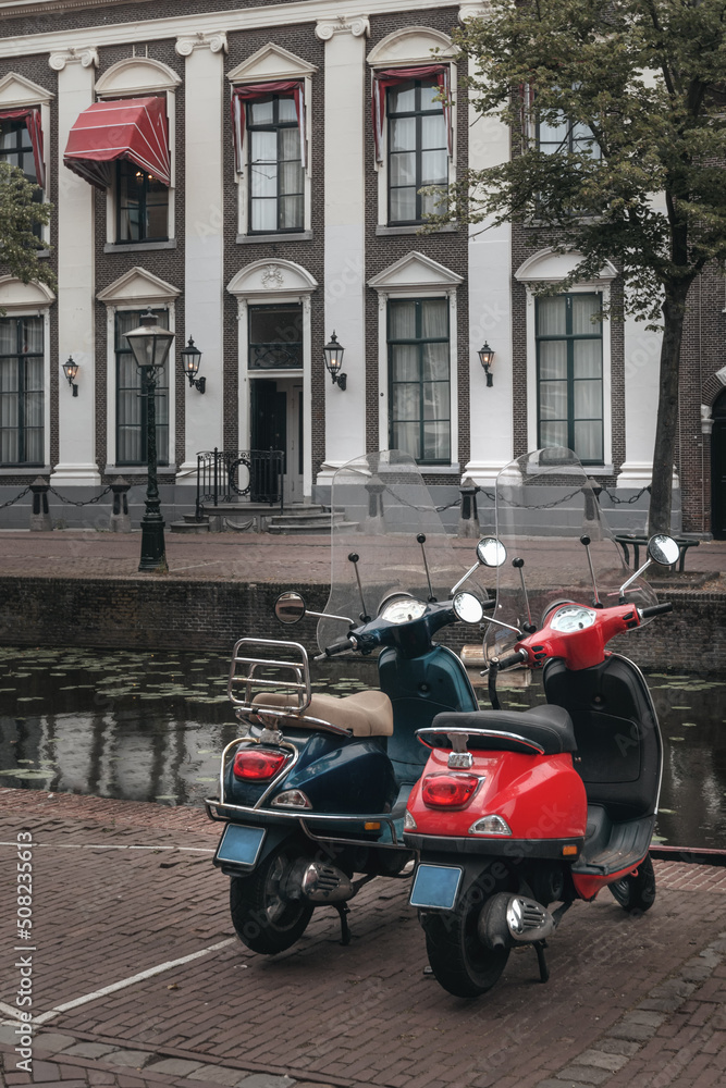 Red and blue scooter parked in Leiden