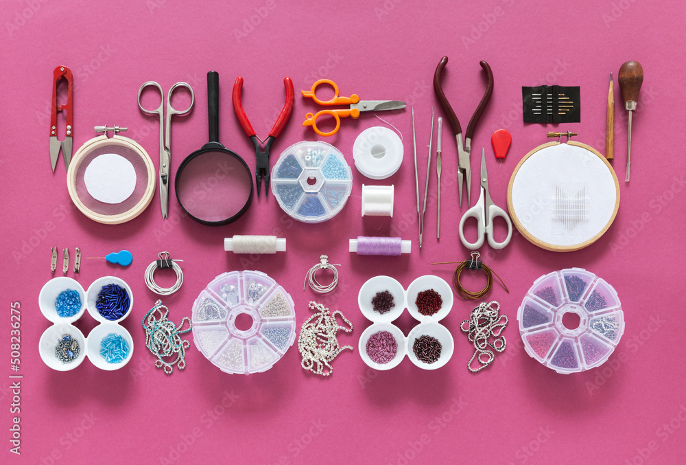 DIY concept. Top view on tools and accessories for embroidery brooches with  beads, bugles, rhinestones and gimps. Sets of beads in containers on pink  background. Fashion hobby, handmade gifts Stock Photo