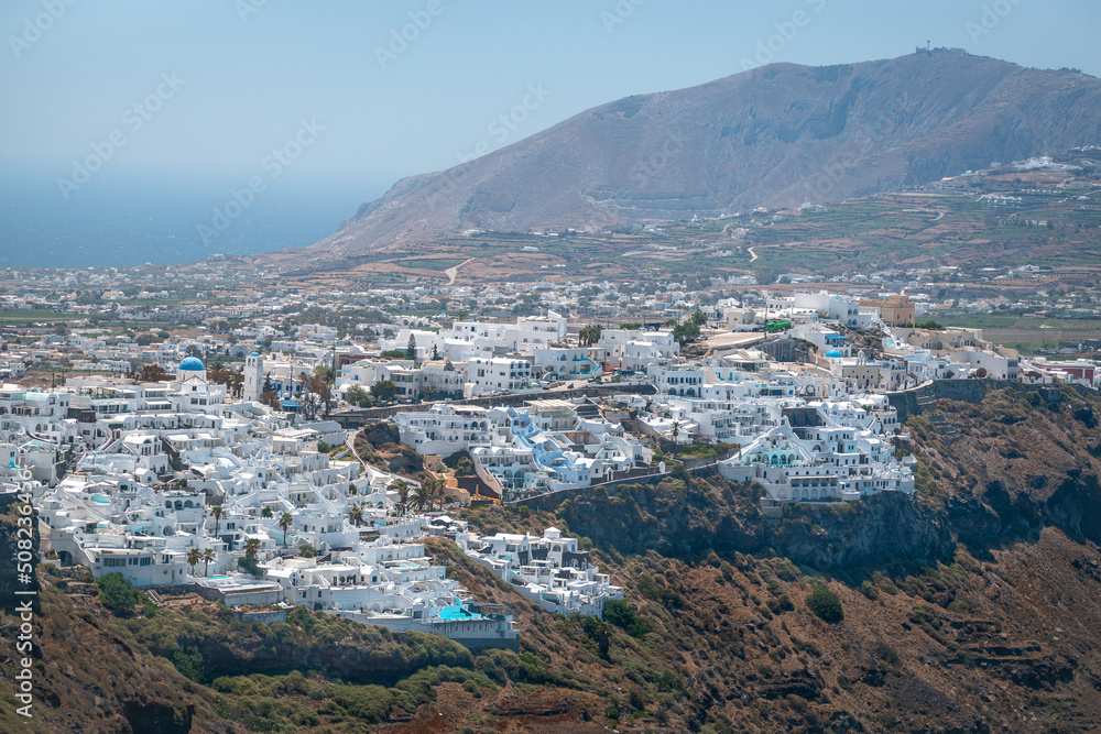 Aerial view of village in Santorini, with mountains in the background