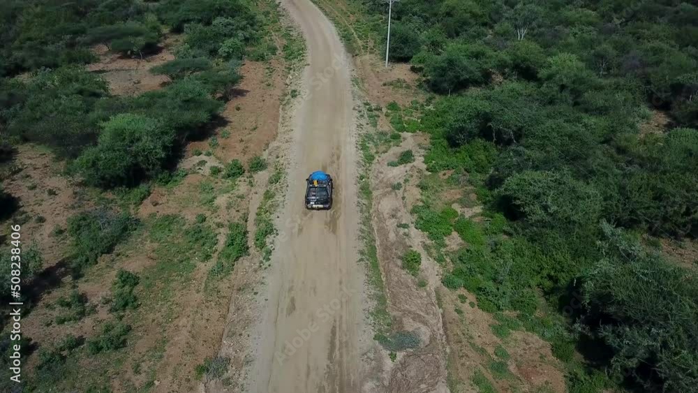 Jeep with tourists driving off road in National Park. Travel scene from exploring Ethiopia, Africa - aerial drone Jeep with tourists driving off road in National Park. Travel scene from exploring Ethiopia, Africa - aerial drone