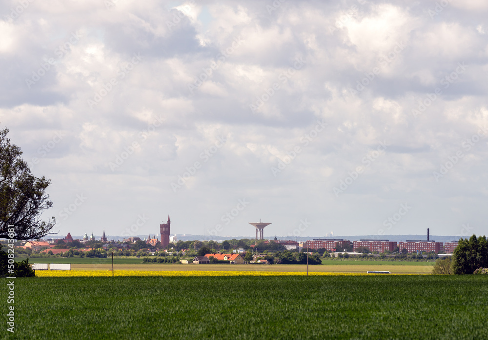 Cityscape Landskrona, Sweden with rapeseed field and grass in foreground. Selective focus