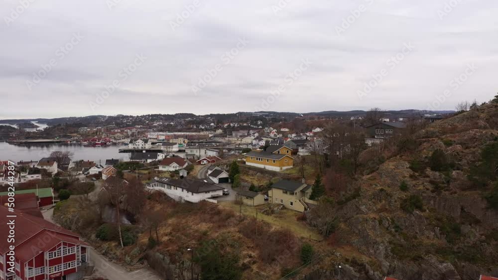 Revealing Grimstad city center when flying over hill from Kjellnabben and Bivika - Norway coastal city aerial at overcast day Revealing Grimstad city center when flying over hill from Kjellnabben and Bivika - Norway coastal city aerial at overcast day