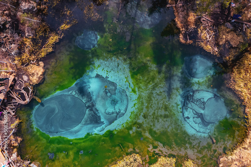 Aerial top view turquoise blue geyser lake in autumn forest Altai mountains Russia