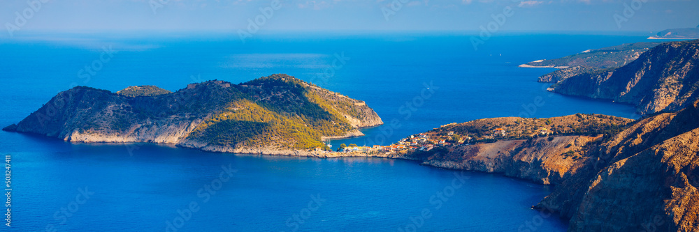 Obraz premium Assos village in Kefalonia, Greece. Turquoise colored bay in Mediterranean sea with beautiful colorful houses in Assos village in Kefalonia, Greece, Ionian island, Cephalonia, Assos village.