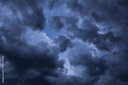 Epic Dramatic storm dark grey cumulus rain clouds against blue sky background texture, thunderstorm 
