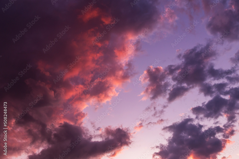 Epic dramatic sunset, sunrise storm sky with dark violet purple clouds in pink red orange sunlight Epic dramatic sunset, sunrise storm sky with dark violet purple clouds in pink red orange sunlight