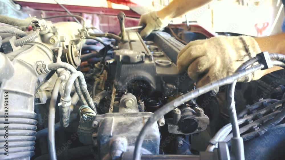 Car engine repair. The mechanic removes the valve cover. A car
