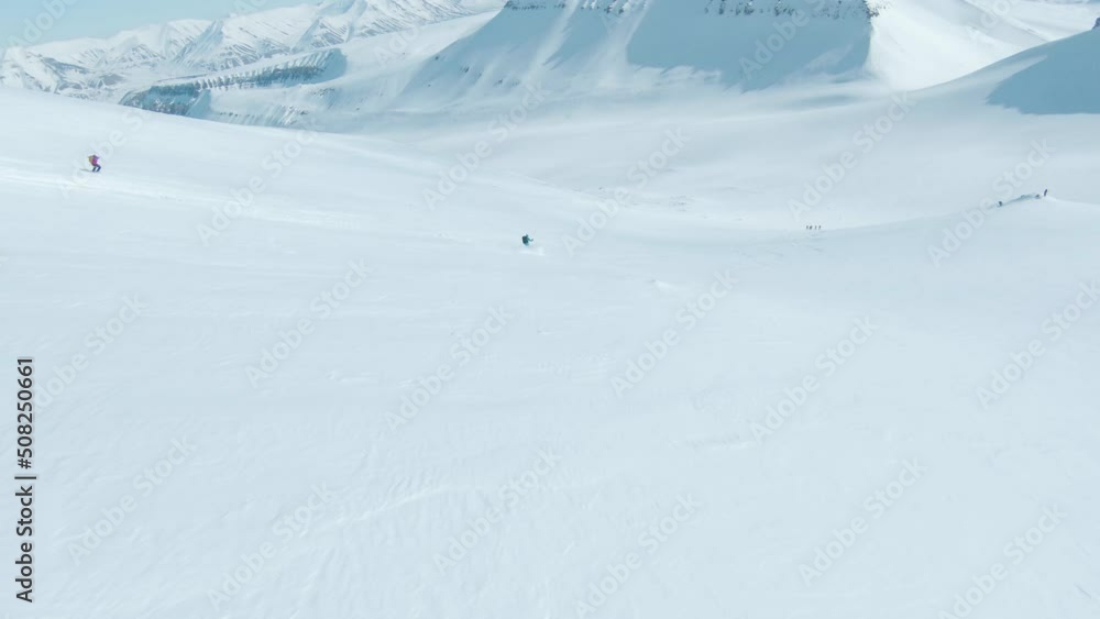 Opening FPV shot of people skiing down pure white slope in Svalbard Opening FPV shot of people skiing down pure white slope in Svalbard