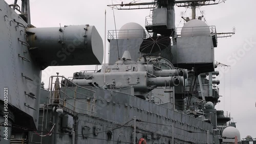 Old warship, dreadnought with armor protection. Ancient Sverdlov-class gun cruiser was built for Soviet Navy. Russian military ship moored in seaport. Naval war vessel, fighting watercraft photo