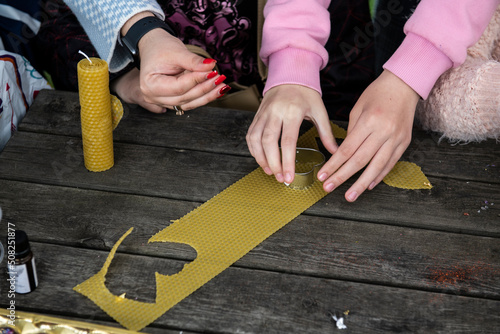 The process of making candles from natural wax in a children's camp
