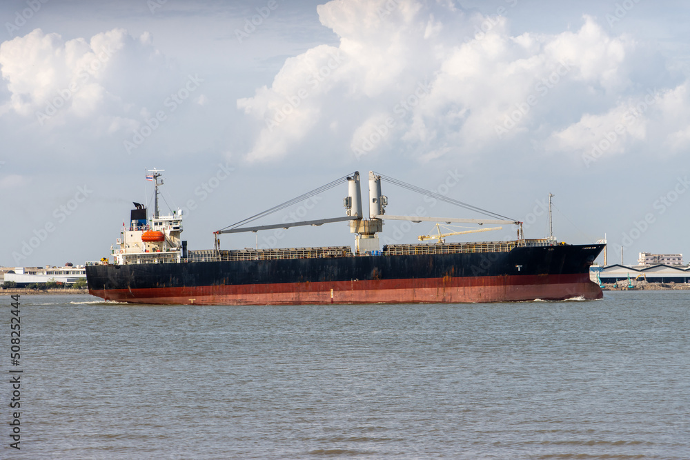 The Cargo Ship sails around a industrial shore