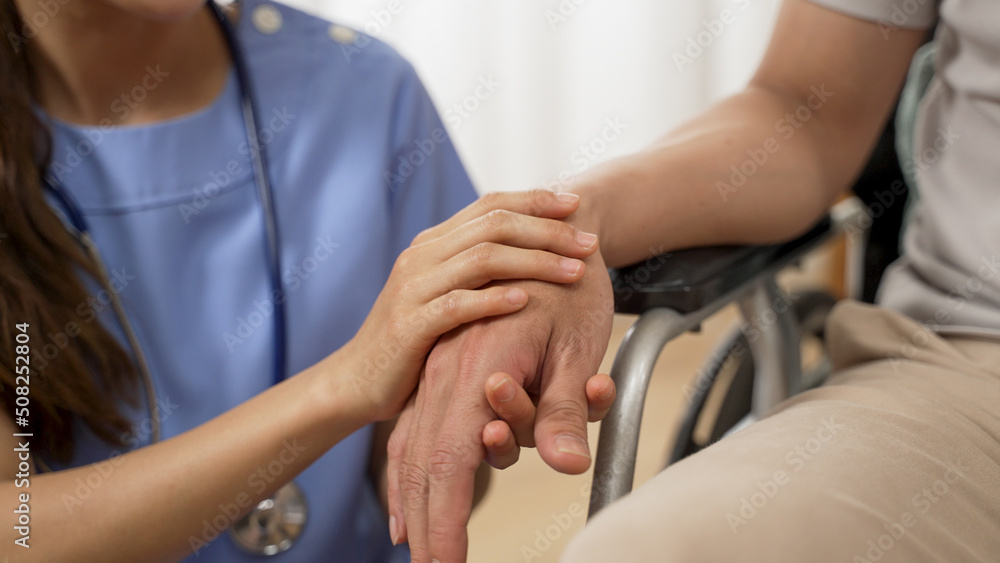 Φωτογραφία closeup with selective focus of hands of nursing aide holding and patting winkled hand of a patient on wheelchair