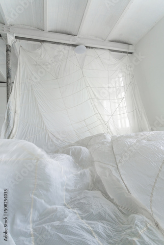 Beautiful parachute hanging from the ceiling of the white photo studio room.