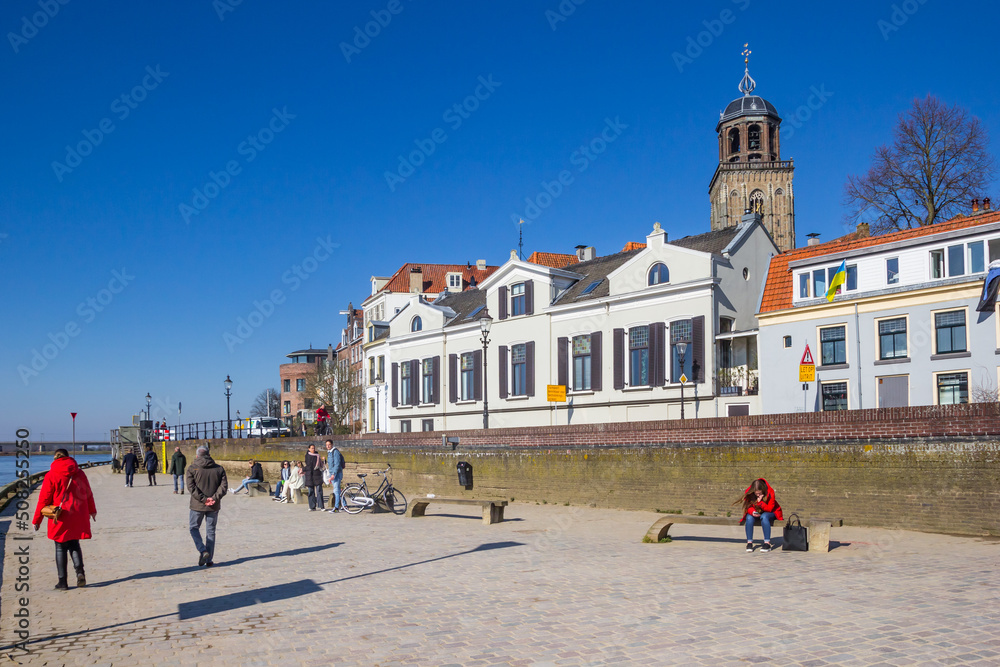 Naklejka premium People walking the promenade along the IJssel river in Deventer, Netherlands
