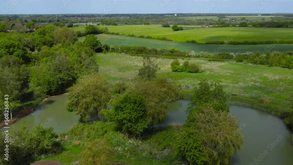 Cinematic view of a calm countryside lake with a green trees Cinematic view of a calm countryside lake with a green trees
