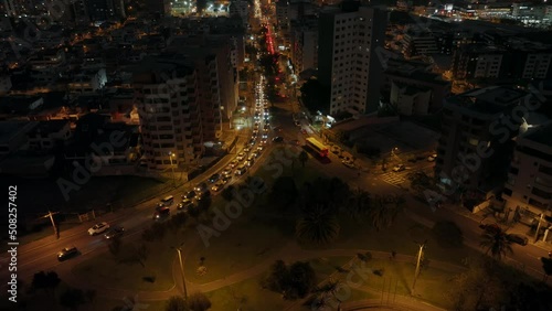 Aerial tilt up shot of Traffic on roads of Quito City during evening and silhouette of mountains in background