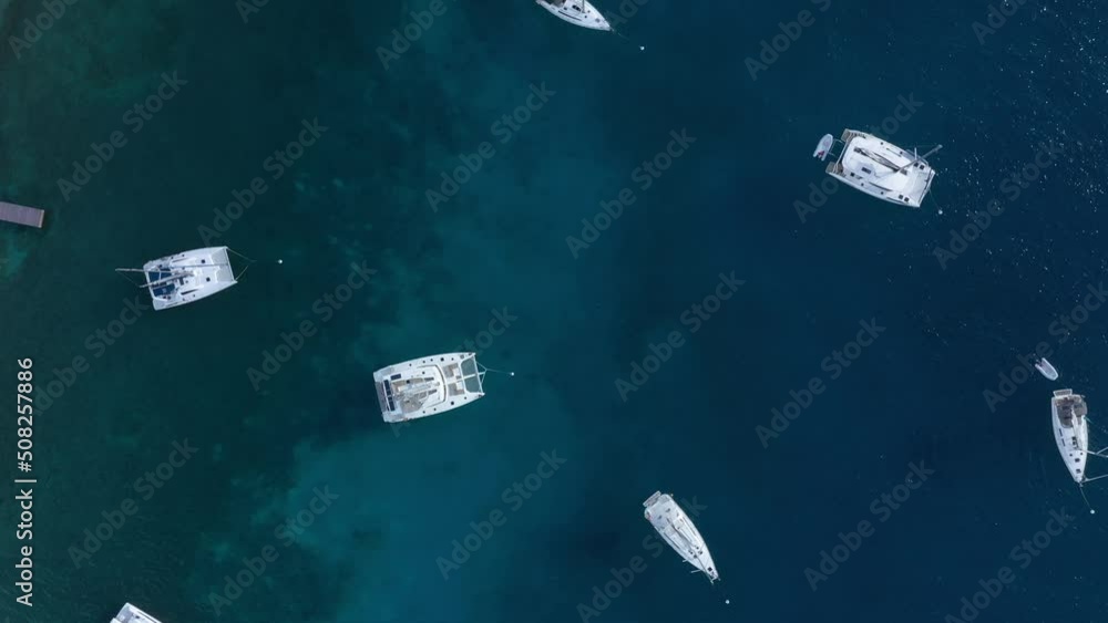 Aerial: Anchored Yachts in the British Virgin Islands. Drone flyover looking down. Aerial: Anchored Yachts in the British Virgin Islands. Drone flyover looking down.