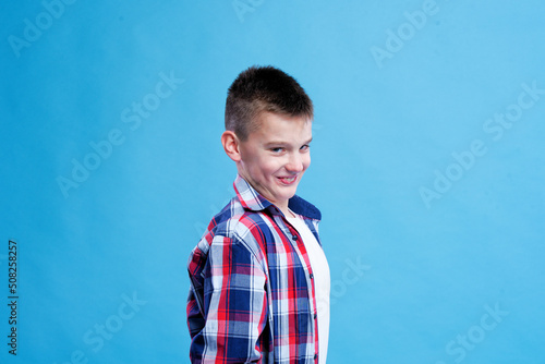 Young teenage boy making a devilish expression, blue background