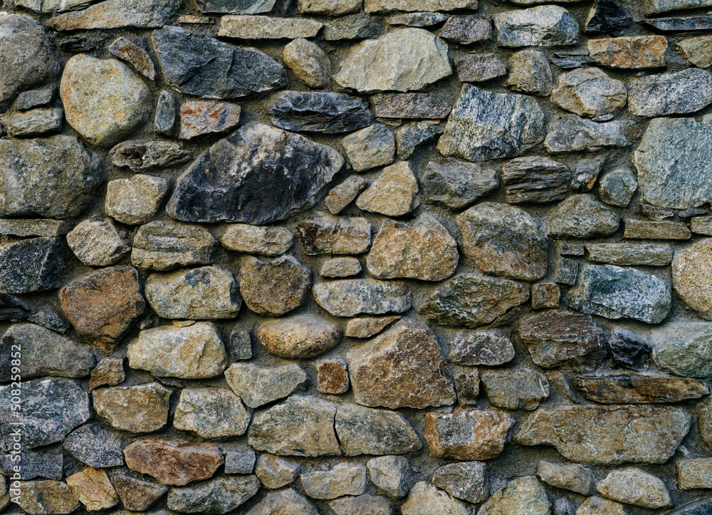 Stone wall rustic texture, with different sized stones background Stone wall rustic texture, with different sized stones background