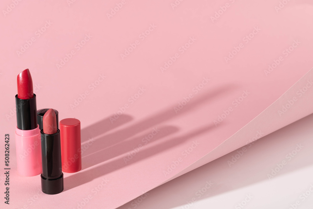 A set of lipsticks on a pink and white background. Hard light. A set of lipsticks on a pink and white background. Hard light.