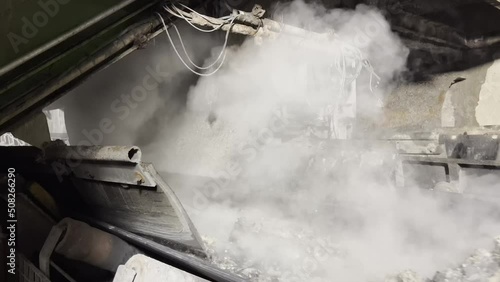 Conveyor belt under an incinerator on which the burnt household waste falls in the form of hot steaming ash