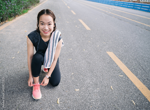 Happy beautiful girl prepare shoe for exercise jogging at outdoor park