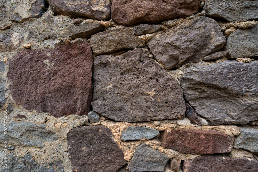 Fototapeta premium Stone wall with abstract pattern under sunlight.