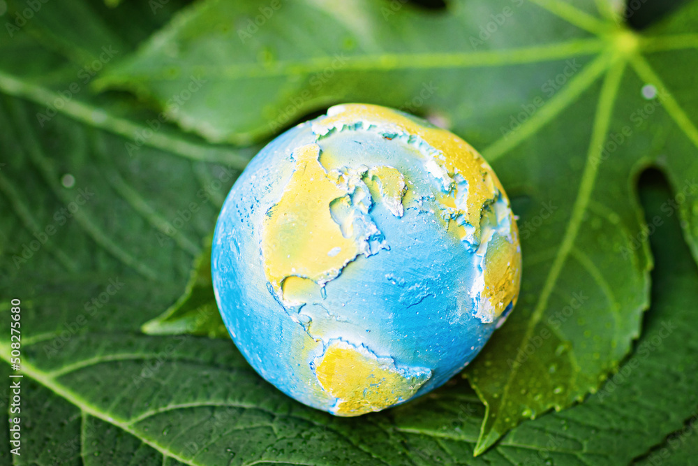Earth planet lying on green leaves. Ecology, environment and Earth day concept. Earth planet lying on green leaves. Ecology, environment and Earth day concept.