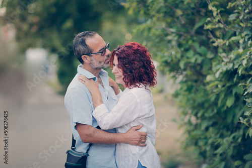 Cute European middle-aged couple hold hands and walk through the streets of the city,, summer walks and travel