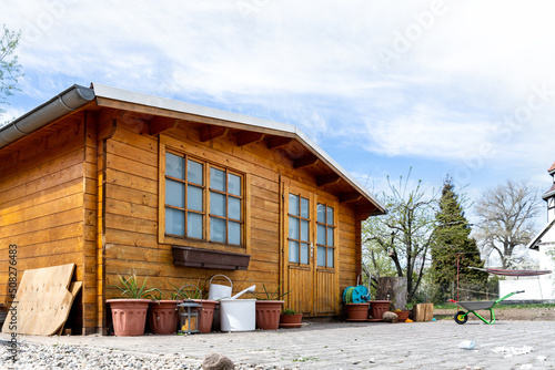 Small beautiful wooden house shed or storage hut for garden tools equipment and bicycles at backyard at beautiful american or european countryside backyard. Cozy rural yard stuff warehouse