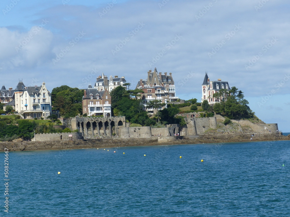 Dinard, France - August 2018 : Walking on the beach of Dinard on the Breton coast / manche. Overview of beautiful and large tourist houses and old fortifications