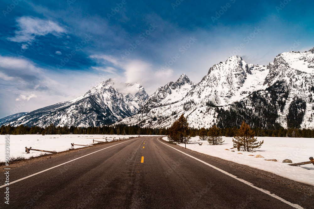 a road leading into the grand Teton mountain range in Wyoming a road leading into the grand Teton mountain range in Wyoming