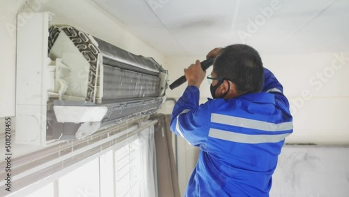 The air conditioning system in the house is being inspected and cleaned by a maintenance specialist. photo