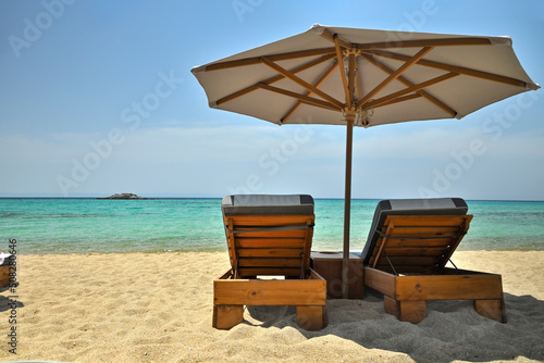 luxurious sunbeds and umbrella on beautiful beach © conzorb