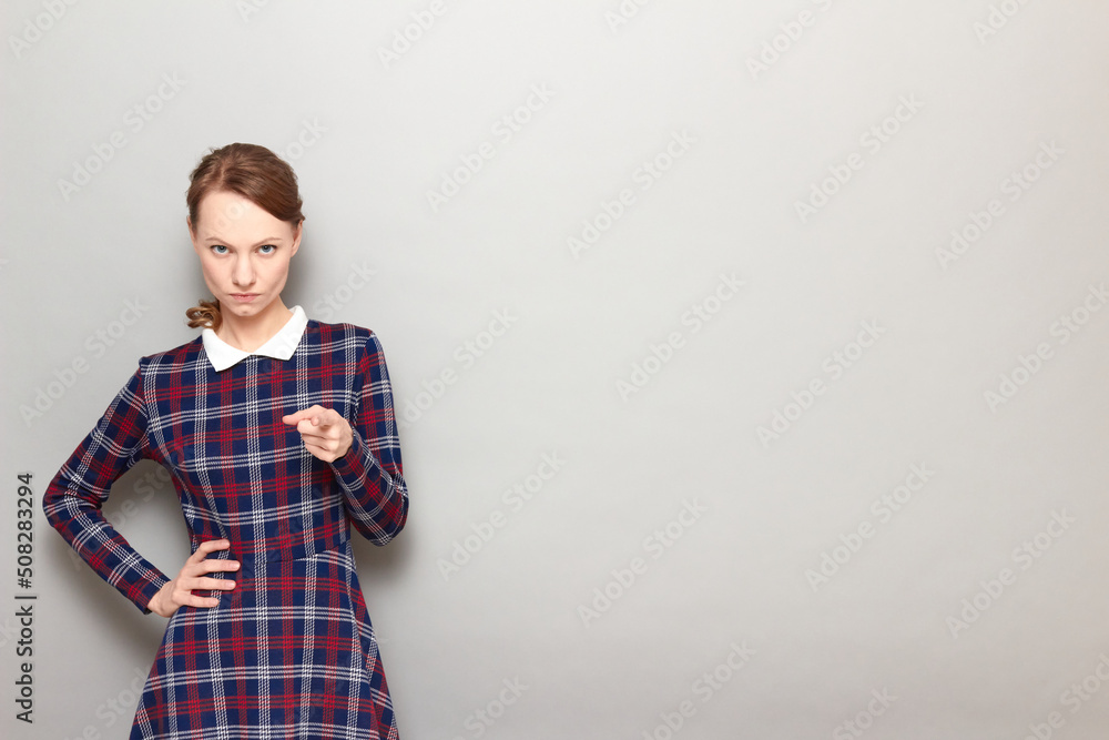 Portrait of serious young woman pointing with index finger at you Portrait of serious young woman pointing with index finger at you