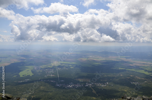 View to the valley with villages, small towns, forest and fields under blue sky with clouds from the trail in the High Tatras Mountains, Slovakia  © Dmytro