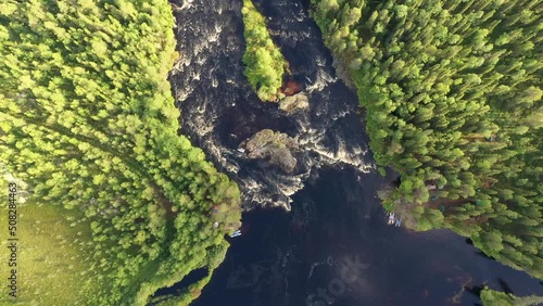 Orbit aerial shot of tourist camps on the banks of Tuntsayoky river and Koshmariki rapid on sunny summer day. Murmansk Oblast, Russia. photo