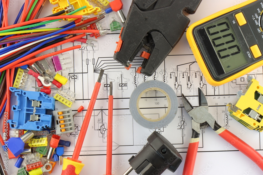 Multimeter and mounting tools in the electrical diagram close-up. Stock