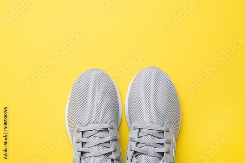 A pair of sneakers for fitness or running on a yellow background. Flat composition. The concept of sport, fitness, healthy lifestyle. Top view.