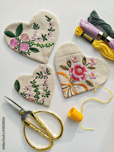 Foto Fabric linen hearts with floral embroidery and vintage scissors, needle, thread