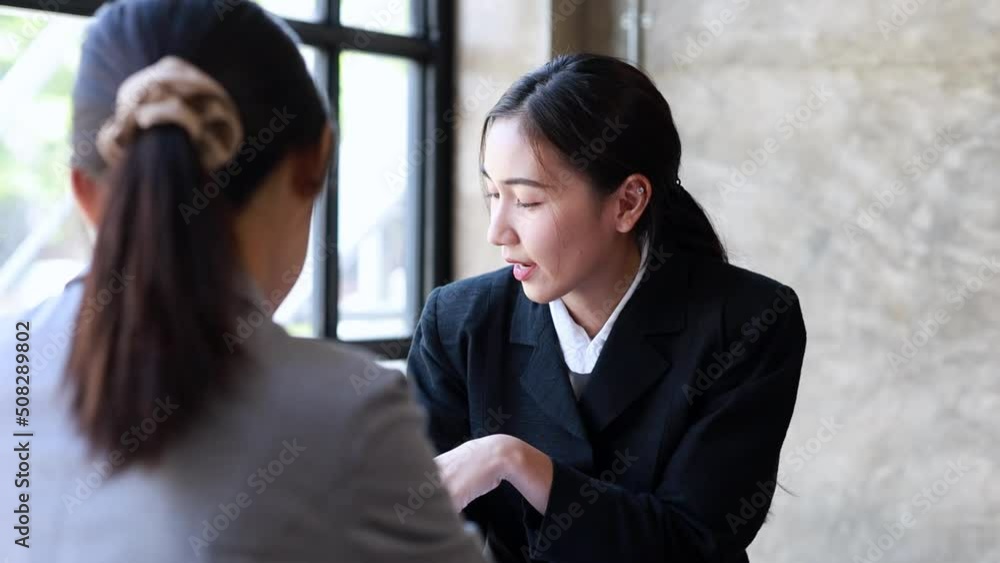Two beautiful Asian women are meeting together in a company meeting room, meeting to discuss plans to develop the business to grow and follow the business plan. Business meeting idea. Two beautiful Asian women are meeting together in a company meeting room, meeting to discuss plans to develop the business to grow and follow the business plan. Business meeting idea.
