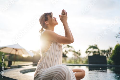 Girl practice yoga and meditate near swimming pool