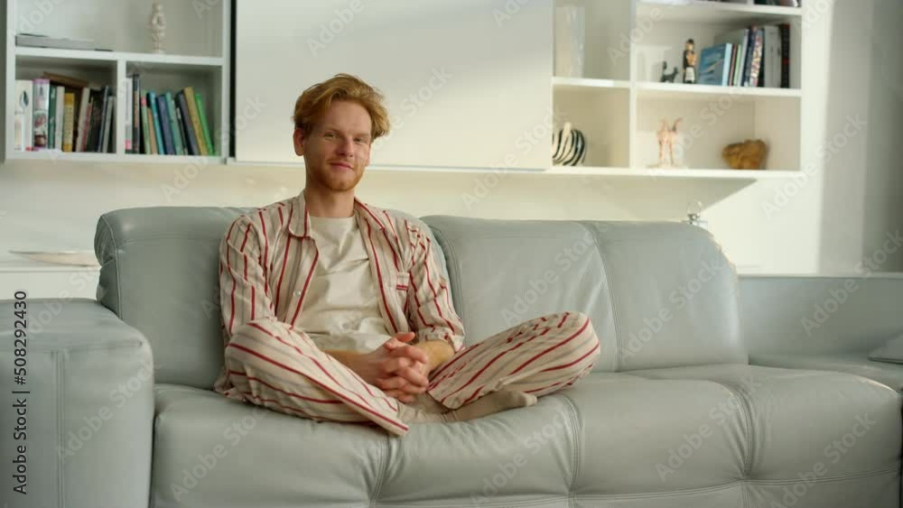 Bachelor man enjoy weekend at home. Joyful ginger freelancer resting in pajamas