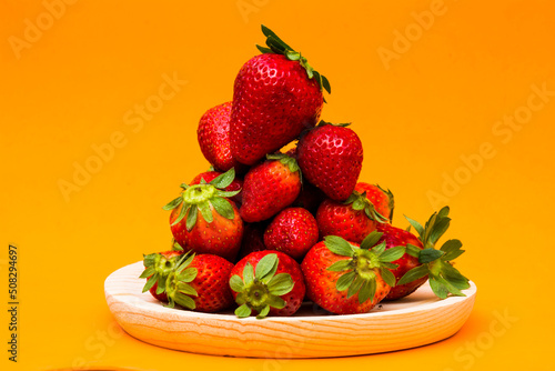 Fresh strawberries on orange background