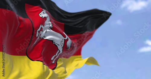 Seamless loop in slow motion with the flag of Lower Saxony waving in the wind on a clear day