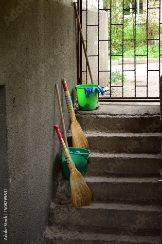 brooms, plastic buckets and gloves for cleaning rooms on the stairs