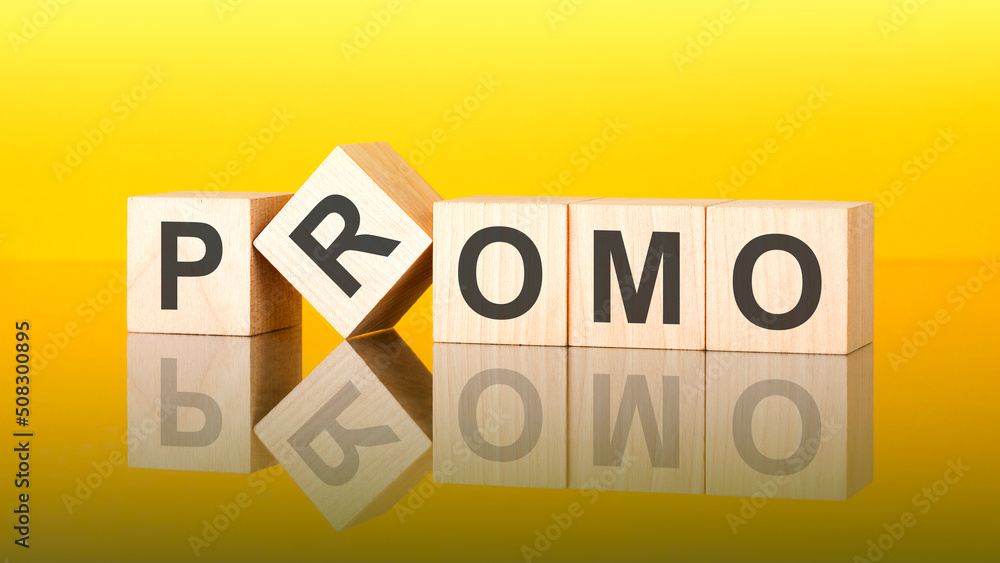 promo word is made of wooden blocks lying on the yellow table, concept promo word is made of wooden blocks lying on the yellow table, concept