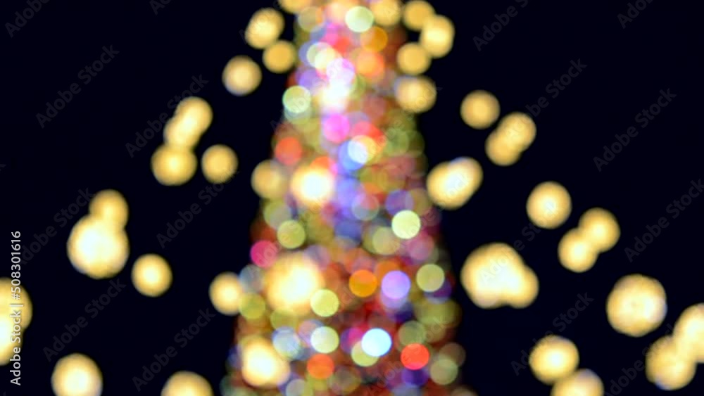 Large New Year's Christmas tree decorated with luminous multi-colored garlands and illumination at night. Christmas tree with flashing lights. Blurred background. New Year and Christmas holidays Large New Year's Christmas tree decorated with luminous multi-colored garlands and illumination at night. Christmas tree with flashing lights. Blurred background. New Year and Christmas holidays