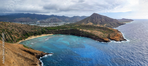 Aerial drone view of famous Hanauma Bay and its beach with koko Head Crater in the background. The beach is known for snorkeling.