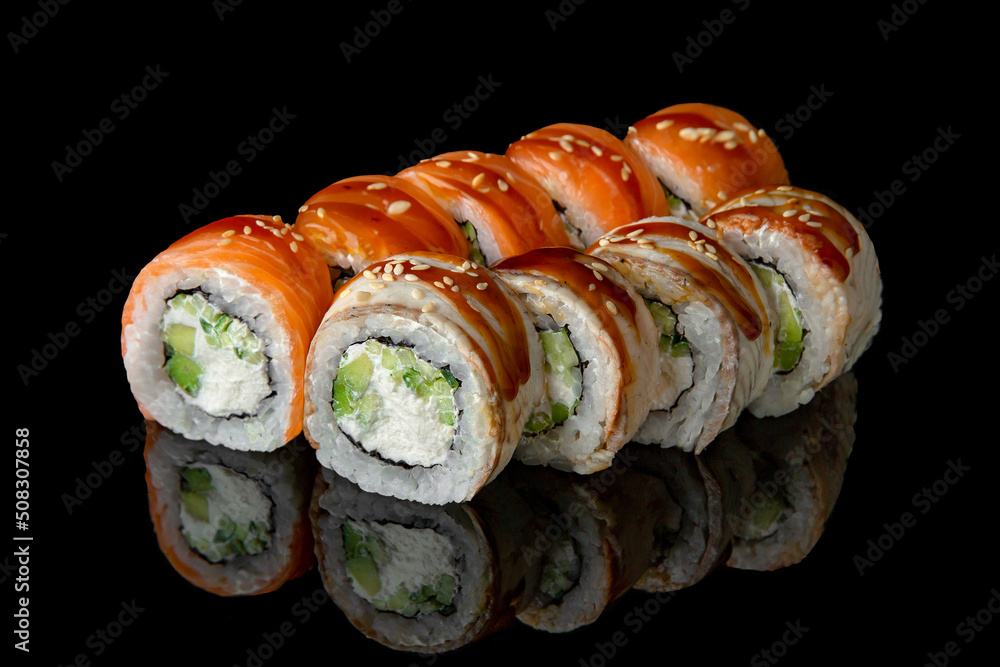 Sushi roll mix with salmon and smoked eel, avocado and cheese on black background. Sushi menu. Japanese food. Sushi roll mix with salmon and smoked eel, avocado and cheese on black background. Sushi menu. Japanese food.